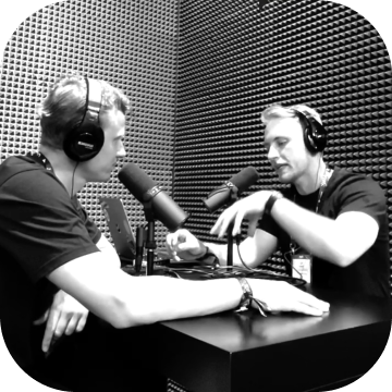 Two people having a conversation during a podcast interview session in a studio.