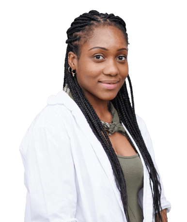 A woman with long braided hair wearing a white jacket over a green top, posing with a slight smile.